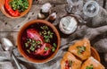 Russian and ukrainian borscht or beet soup with sour cream, buns, garlic on a wooden rustic background with vodka. Top view Royalty Free Stock Photo