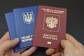 Russian and Ukrainian passport in hand