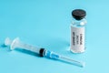 Russian vaccine Sputnik V and syringe injection against blue background. Coronavirus vaccine. COVID-19 immunization