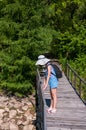 Russian village, summer landscape girl in a hat on the bridge over the lake