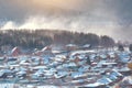 Russian village winter. Roofs covered with snow, a Blizzard sweeps in the forest Royalty Free Stock Photo