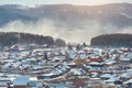 Russian village winter. Roofs covered with snow, a Blizzard sweeps in the forest Royalty Free Stock Photo