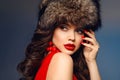 Russian winter beauty woman portrait. Fashion girl model with fur hat. Beautiful brunette with red lips makeup, manicured nails Royalty Free Stock Photo