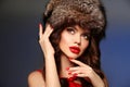 Russian winter beauty woman portrait. Fashion girl model with fur hat. Beautiful brunette with red lips makeup, manicured nails Royalty Free Stock Photo