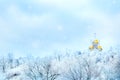 Russian winter landscape. Golden domes of the church against the background of a winter white forest. Snowing Royalty Free Stock Photo