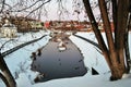 Russian winter scene. A pond partly frozen surrounded by the snow.