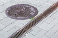 A rust lattice of a drainage paving system and round sewer manhole. Royalty Free Stock Photo