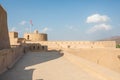 Rustaq castle with an Omani flag on a sunny day.