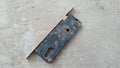 Rusted black door key on gray cement floor