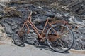 Rusted bycicle on rocks background Royalty Free Stock Photo