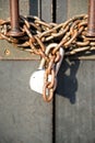 A rusted chainlink and padlock on an old building