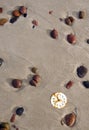 Rusted clock dial on beach sand and stones