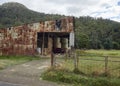 Rusted corrugated iron barn or shed with hay in field