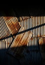 Rusted corrugated metal sheets arranged in an overlapping pattern. Sunlight casts Royalty Free Stock Photo
