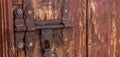 A rusted door lock and aldrop on a brown door Royalty Free Stock Photo