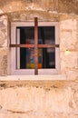 Rusted flat iron cross in front of window, for security Royalty Free Stock Photo