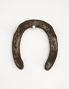 Rusted horseshoe hanged on a white wall