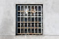 Rusted metal bars protection covering old broken window with safety glass and dilapidated cracked wooden frame Royalty Free Stock Photo