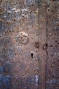 A rusted metal door with three rings, and an antique lock Royalty Free Stock Photo