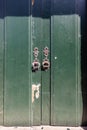 Rusted metal pulls on an old green door