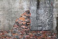 A rusted old broken fading plaster red brick back garden wall with water stains cracks and discolorations perfect for background