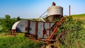 Rusted old combine forgotten in the weeds