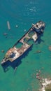 Rusted old tanker shipwreck stranded near the rugged coast