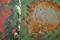 Rusted piece of iron with red, green, white and grey paint