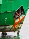 Rusted Raised Anchor on Dark Green Ship