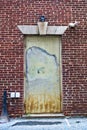 Rusted steel door set inside a brick wall. Royalty Free Stock Photo