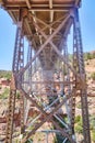 Rusted Steel Truss Bridge Underbelly with Red Rock Background