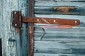 Rusted strap hinge on a fence gate door with shiny stainless bolt heads. Royalty Free Stock Photo