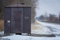 Rusted Train Relay House Next to Snowy Train Tracks