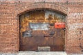 Rusted warehouse delivery receiving bay door red brick building alley