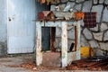 Rusted workbench vice mounted on old metal table surrounded with building material and garbage on stone wall and locked door Royalty Free Stock Photo