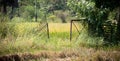 Rustic aged metal gate opening into t he paddy field, rural village landscape photograph Royalty Free Stock Photo