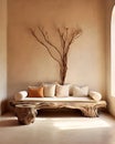 Rustic aged wood tree trunk bench with pillows near stucco wall with dried twig decor. Boho interior design of modern living room
