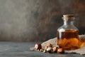 Rustic amber bottle of hazelnut oil with scattered hazelnuts on textured background Royalty Free Stock Photo