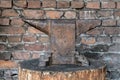 Rustic anvil on wooden stump.