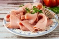 Rustic arrangement of an exquisite ham or prosciutto cotto on a vintage plate on a country table. high view