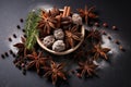 Rustic assortment of spices including star anise cinnamon sticks and chocolate truffles on a dark textured backdrop