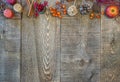 Wood background with candles, apples, berries, cinnamon, pinecone and fall decor along top border