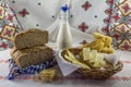 Rustic background: artisan bread, milk bottle, pasta and slices of bread and butter in a wicker basket Royalty Free Stock Photo