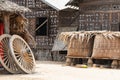 Rustic backyard with bamboo hut, baskets and two wooden wheels Royalty Free Stock Photo