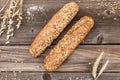 Rustic baguette and wheat on an old vintage wood table.