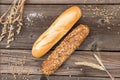 Rustic baguette and wheat on an old vintage wood table.