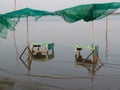 Rustic beach umbrellas and two tables in Kratie, Cambodia.