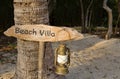 A rustic beach villa sign with oil lamp