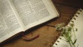 Rustic Bible on a Wooden Background with Notepad and Flowers