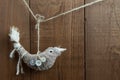 Rustic bird Christmas decoration hanging on wood background.